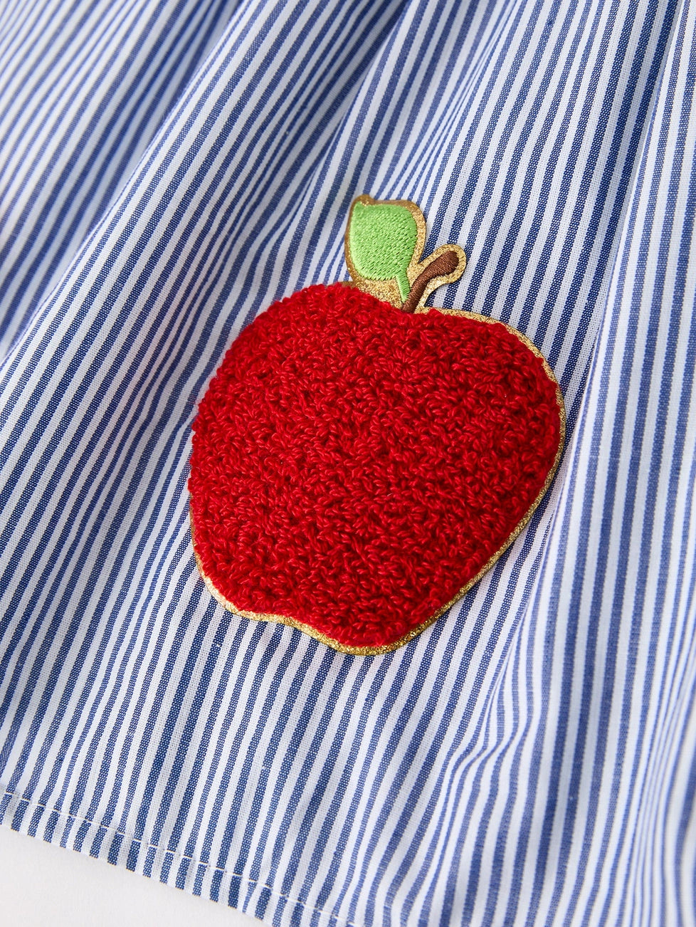 Red apple patch on a blue and white striped dress